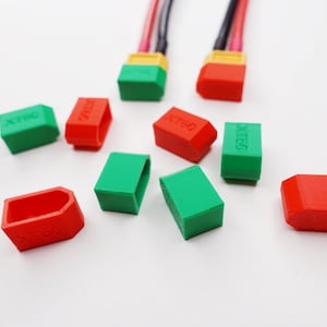 Puede incluir: Surtido de tapas de conector XT60 rojas y verdes. Las tapas son de plástico y tienen el texto "XT60" impreso.