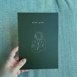 Puede incluir: Una tarjeta verde oscuro con texto blanco que dice "go gina, go gina" y un dibujo de línea blanca de una mujer con los brazos cruzados.