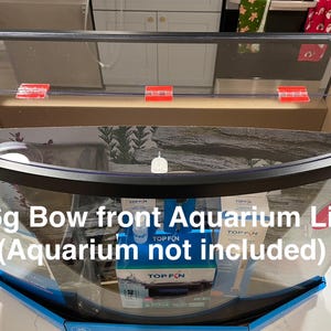 Könnte beinhalten: Eine weiße Keramik-Tasse mit schwarzem Henkel und dem Text "But First, Coffee" in fetter, schwarzer Schrift. Die Tasse steht vor einem verschwommenen Hintergrund, der eine gemütliche Umgebung andeutet.