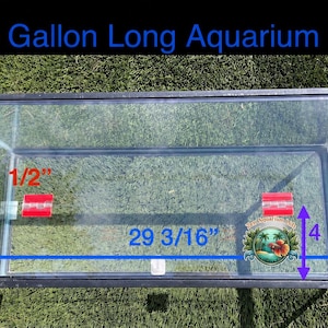 Op de afbeelding: Een rechthoekige 20 Gallon Long aquariumdeksel met een zwart frame en heldere glazen panelen. De deksel heeft rode scharnieren en meet 29,21 cm in breedte en 74,14 cm in lengte, met een sectie van 11,43 cm. Inclusief een klein rond logo.