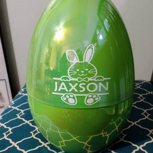 May include: A large green plastic Easter egg with a white bunny and the name "Jaxson" on it.