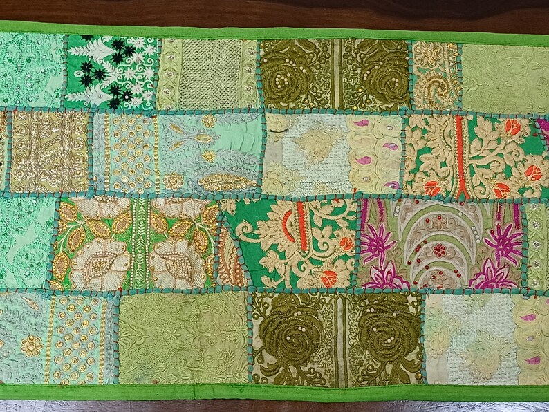 K&ouml;nnte beinhalten: Ein gr&uuml;nes Patchwork-Wurfkissen mit verschiedenen floralen und geometrischen Mustern in Gr&uuml;n-, Gold- und Rosat&ouml;nen.
