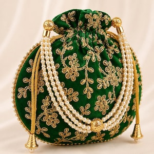 May include: A round green velvet drawstring pouch featuring intricate gold thread embroidery in a floral pattern. The bag includes a triple-strand faux pearl handle with gold-toned metal accents and decorative gold-toned conical tassels at the base.
