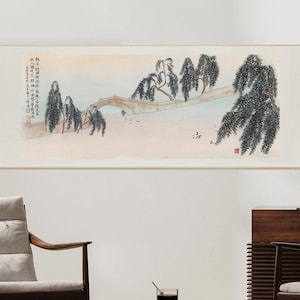 以下が含まれることがあります： 橋と柳の木が描かれた、伝統的な中国の絵画の巻物。絵画は黒、白、グレーの色合いで、ピンクとブルーのヒントがあります。