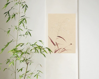 Può includere: Un rotolo bianco con sfondo beige che presenta un delicato disegno a inchiostro di una singola pianta con fiori bianchi e un piccolo insetto. Il rotolo è appeso a una parete bianca accanto a una pianta di bambù in vaso.