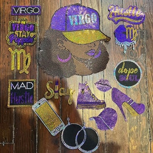 Puede incluir: Un surtido de parches y accesorios cubiertos de pedrería, que incluyen una gorra de béisbol morada y dorada con "VIRGO", un zapato de tacón alto y una zapatilla deportiva. Otros parches incluyen las palabras "Hustle", "Stay" y "Dope Soul".