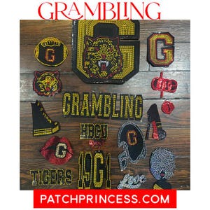 Op de afbeelding: Een verzameling strass-patches met het woord "GRAMBLING" en "TIGERS" in goud. Patches omvatten een tijger, een voetbal, lippen, een hoge hak en de letters "G" en "HBCU". De website "PATCHPRINCESS.COM" is ook zichtbaar.