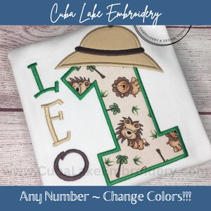 May include: Embroidered design of the letter "L" with a safari hat, a number "1" with a jungle animal print, and the text "Any Number ~ Change Colors!!!".