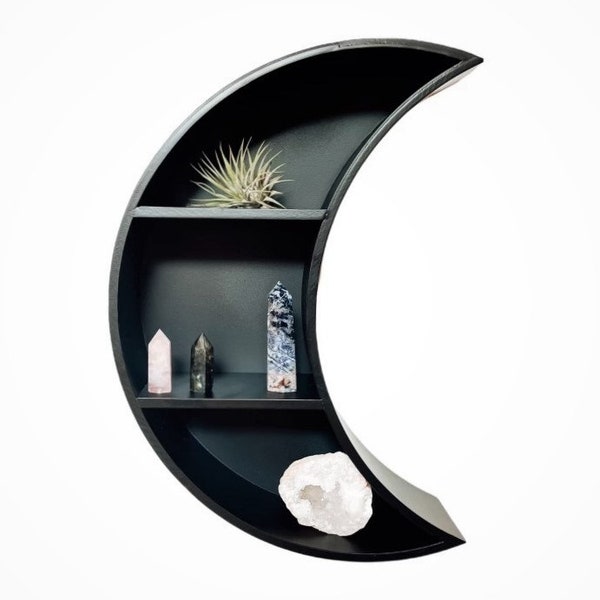 May include: Black crescent moon shaped shelf with four shelves. The shelf is decorated with crystals and a small succulent plant.