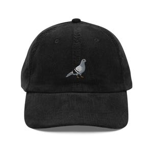 Puede incluir: Una gorra de béisbol de pana negra con una imagen bordada de una paloma gris.