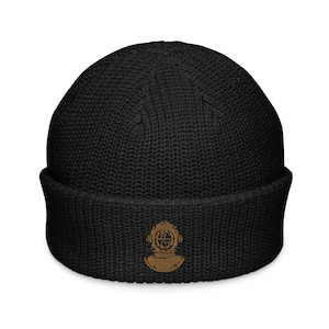 May include: Black knitted beanie with a brown embroidered diving helmet graphic.