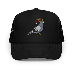 May include: Black trucker hat featuring an embroidered pigeon wearing a jester's hat. The pigeon is gray, white, and black with yellow feet. The jester's hat has red, green, and yellow accents. The hat has a mesh back.