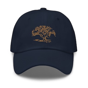 May include: A navy blue baseball cap with a brown embroidered tree design.