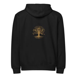 May include: Black hooded sweatshirt with a gold tree of life design on the back. The tree features a detailed trunk, roots, and branches with small circular accents. The sweatshirt has a drawstring hood and a kangaroo pocket.