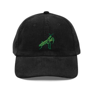 Può includere: Cappellino da baseball nero in velluto a coste con un ricamo verde raffigurante una mantide religiosa. Il cappellino ha una visiera curva e un cinturino regolabile. Un accessorio alla moda per gli amanti degli insetti.
