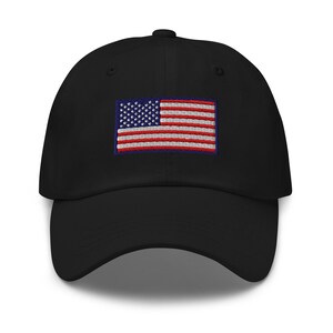 May include: Black baseball cap with an embroidered American flag patch. The flag features red and white stripes and a blue square with white stars. The cap has a curved brim and a button on top.