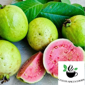 May include: Close-up of fresh green guavas and a halved pink guava with visible seeds. The guavas are on a white surface with green leaves in the background. The image includes the text "CEYLON SPICES FOODS".
