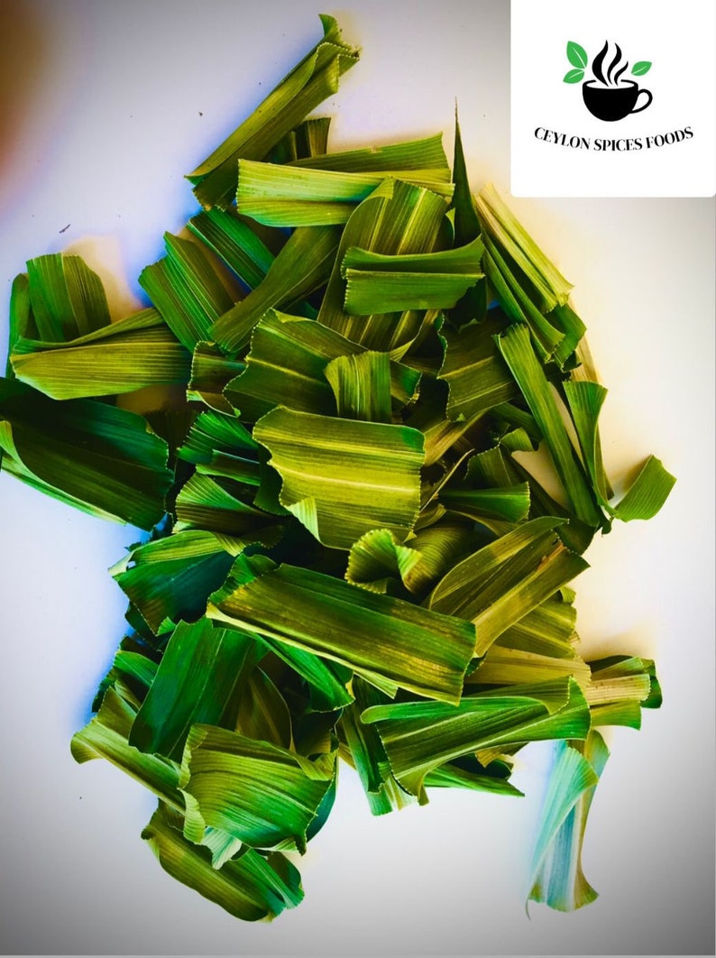 May include: A collection of dried, vibrant green pandan leaves cut into small, rectangular segments. The leaves feature visible longitudinal veins and a textured surface. A white square logo with a black coffee cup icon and the text CEYLON SPICES FOODS is visible in the top right corner.