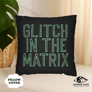 Può includere: Federa per cuscino nera con la scritta "GLITCH IN THE MATRIX" in verde neon. Il cuscino quadrato è appoggiato su una superficie bianca. Le parole "PILLOW COVER" sono stampate su un ovale bianco.