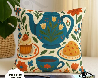 May include: Square pillow cover with a whimsical tea party design. The teal teapot, teacup, and treats are set against a cream background with floral accents. The words "PILLOW COVER" are printed on the bottom left.
