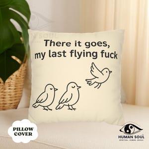 May include: Cream cushion cover featuring the phrase "There it goes, my last flying fuck" and three cartoon birds. The design is minimalist, with black line art on a cream background.