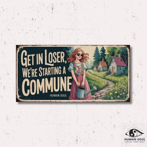 Może przedstawiać: Prostokątny metalowy znak z napisem "GET IN LOSER, WE'RE STARTING A COMMUNE" i ilustracją kobiety z konewką. Grafika przedstawia wiejską scenę z domami i ścieżką. Znak ma postarzany, vintage wygląd.