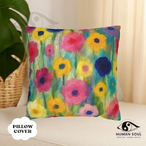 May include: Square pillow cover with a vibrant floral watercolor design. The pillow features pink, yellow, and blue flowers on a light green and blue background. The words "PILLOW COVER" are printed on the bottom left.