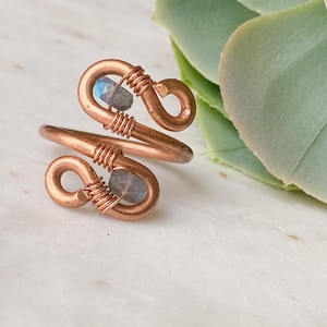 May include: A copper wire ring with two labradorite stones wrapped around the band.