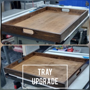 May include: A dark brown wooden serving tray with two handles. The tray is made of wood with a natural grain pattern. The text "TRAY UPGRADE" is printed on the tray.