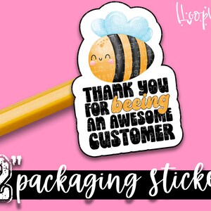 Può includere: Un adesivo per imballaggio da 5 cm con un'illustrazione di un'ape dei cartoni animati. L'ape ha una faccia sorridente ed è circondata da una nuvola. L'adesivo dice: "Grazie per essere un cliente fantastico."