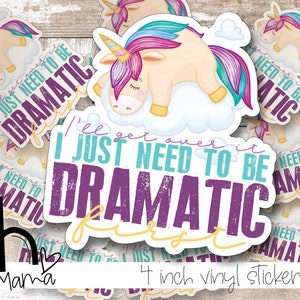 May include: A 4 inch vinyl sticker decal featuring a cartoon unicorn with a rainbow mane and tail, sleeping on a cloud. The sticker has the text "I'll get over it I just need to be dramatic first" in purple, teal, and white text.