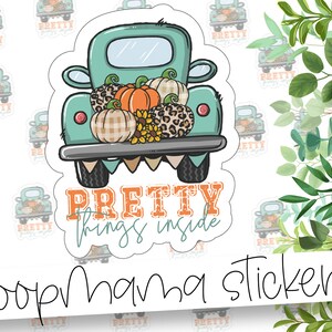 May include: A teal blue pickup truck with a white bed filled with pumpkins, gourds, and sunflowers. The truck has the text "Pretty things inside" written on the front. The image is a sticker.