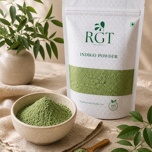 Könnte beinhalten: Ein weißer Beutel mit RGT Organics Indigo-Pulver neben einer kleinen Schüssel und einem Holzlöffel, die mit grünem Pulver gefüllt sind. Auf dem Beutel steht "Indigo Powder" und "Healthy Food, Healthy You". Im Hintergrund eine kleine Vase mit grünen Blättern.