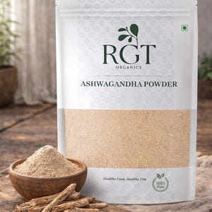 Puede incluir: Una bolsa blanca de polvo de Ashwagandha con el texto "RGT Organics" y "Ashwagandha Powder". Un cuenco de madera con polvo y una tabla de cortar de madera con raíces están delante. El texto "Healthy Food, Healthy You" también es visible.