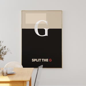 Pode incluir: Uma impress&atilde;o art&iacute;stica emoldurada com uma borda dourada. A obra apresenta uma grande letra "G" branca sobre um fundo de duas cores bege e preto. O texto "SPLIT THE G" est&aacute; na parte inferior, com o "G" em vermelho.