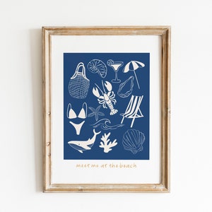 May include: A framed print with a blue background and white illustrations of beach-themed items, including a swimsuit, a beach chair, a seashell, a lobster, a starfish, a cocktail glass, an umbrella, a net bag, and a whale. The text "meet me at the beach" is at the bottom of the print.