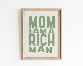 May include: A framed print with the text "MOM I AM A RICH MAN" in green letters on a beige background.