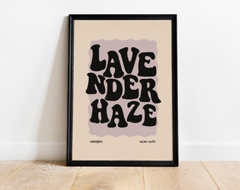May include: A black framed print with a light pink background and the text "Lavender Haze" in black, stylised lettering. The text is from the song "Lavender Haze" by Taylor Swift.