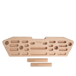 May include: A light-colored wooden climbing training board with various handholds and two cylindrical wooden dowels. The board features multiple holes, pockets, and slopers for grip training. The brand name "WHITE OAK PLUS" is visible.