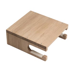 May include: A light-colored wooden desk organizer with a rectangular top and a lower section with a curved cutout. The organizer has two white supports and is made of light-colored wood. The organizer is designed to hold items.