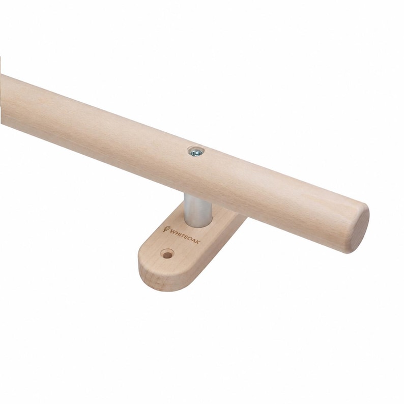 K&ouml;nnte beinhalten: Ein heller Holzhandlauf mit einer zylindrischen Stange, die an einer Wandhalterung befestigt ist. Die Halterung verf&uuml;gt &uuml;ber einen kleinen Metallpfosten, eine sichtbare Schraube auf der Stange und den Markennamen WHITEOAK auf dem Holz.