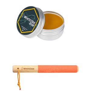 Puede incluir: Una pequeña lata de bálsamo reparador de cera de abeja amarilla con una etiqueta negra y amarilla que dice "Whiteoak Repair" y "Handmade for Climbers". También se muestra un palo de madera con una esponja de color coral en el extremo. El palo tiene las palabras "Whiteoak" impresas.