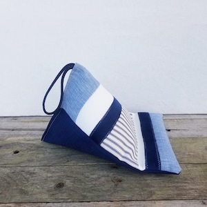 以下が含まれることがあります： ハンドル付きの青と白のストライプのファブリックトートバッグ。バッグはデニムやストライプの生地など、さまざまな生地のパッチワークで作られています。