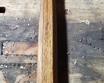 May include: A wooden-handled hammer with a black metal head. The hammer is resting on a wooden surface.