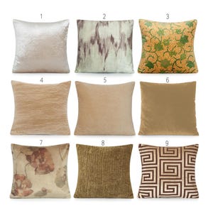 May include: Nine decorative throw pillows in various designs and colors. Pillows include a light beige crushed velvet, a light green and brown abstract pattern, a yellow-orange floral design, and solid tan, beige, and brown velvet options. Other pillows have textured and geometric patterns.