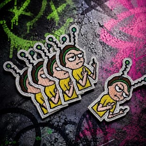 May include: Four embroidered patches featuring a cartoon character with brown hair, a green headband, and a yellow shirt. The character has a metallic antenna on their head with a glowing green tip and is gesturing with a middle finger on each hand.