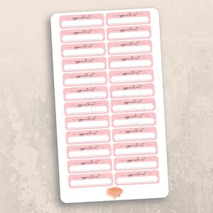 May include: A sheet of pink and white appointment stickers with the word "appointment" written in black cursive on each sticker.