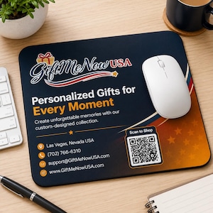 May include: A rectangular mousepad with a white wireless mouse. The mousepad has a dark blue background with orange and gold accents. Text on the mousepad reads "GiftMe Now USA" and "Personalized Gifts for Every Moment."