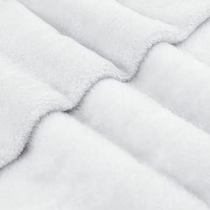 A close-up view of a soft, fluffy white fabric, possibly a blanket or cushion, with a textured and wrinkled appearance.