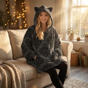 May include: A white ceramic mug with a black handle and the text "But First, Coffee" in a black, bold font. The mug is on a white surface. The mug is approximately 4 inches tall.